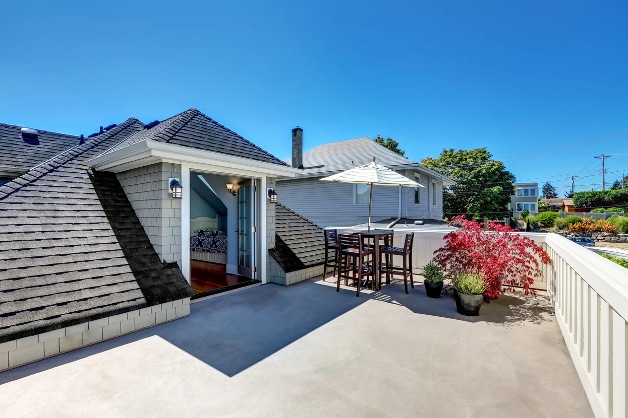 Terrasse extérieure d'une maison résidentielle avec mobilier de jardin et parasol