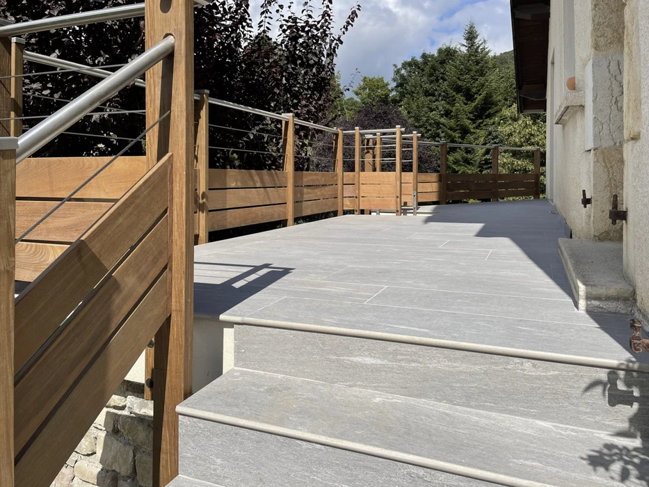 Terrasse extérieure avec escalier en béton et garde-corps en bois
