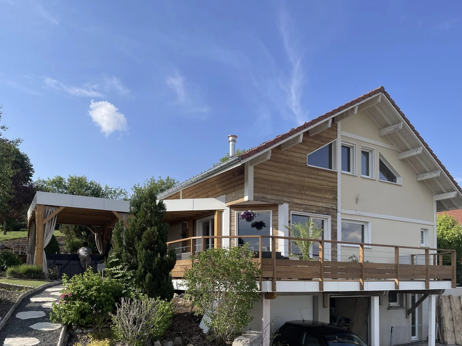 Maison contemporaine à ossature bois avec bardage horizontal et enduit clair, toiture tuiles rouges