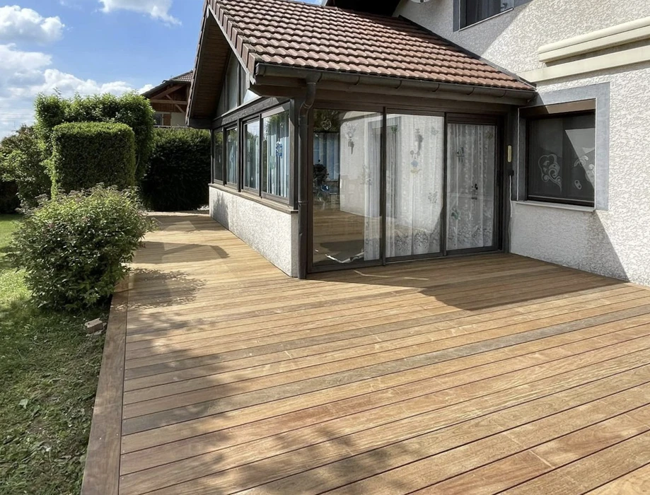 Maison modulaire contemporaine en bois avec terrasse surélevée dans environnement naturel boisé
