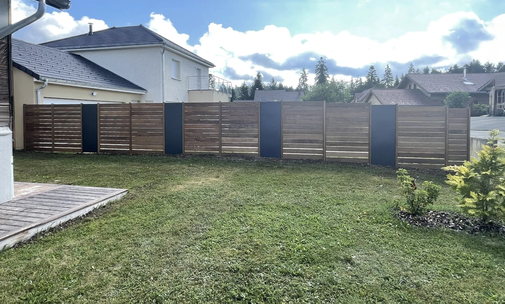 Maison individuelle moderne avec terrasse surélevée en bois et balcon à garde-corps métalliques horizontaux