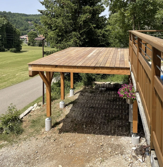 Maison modulaire contemporaine en bois avec terrasse surélevée dans environnement naturel boisé